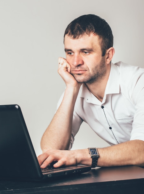 Zajęty Mężczyzna Siedzi Przy Laptopie W Pokoju.