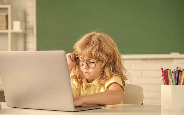 Zajęty nastolatek w klasie z powrotem do szkoły dzień wiedzy koncepcja edukacji online