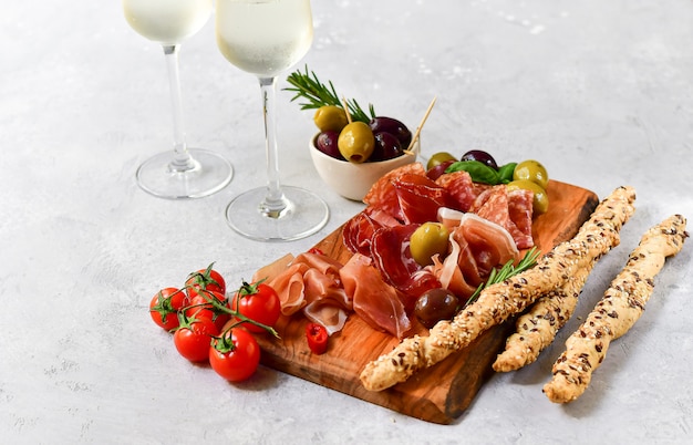 Zakąska we włoskiej restauracji z prosciutto i salami, oliwkami i dwiema szklankami prosecco