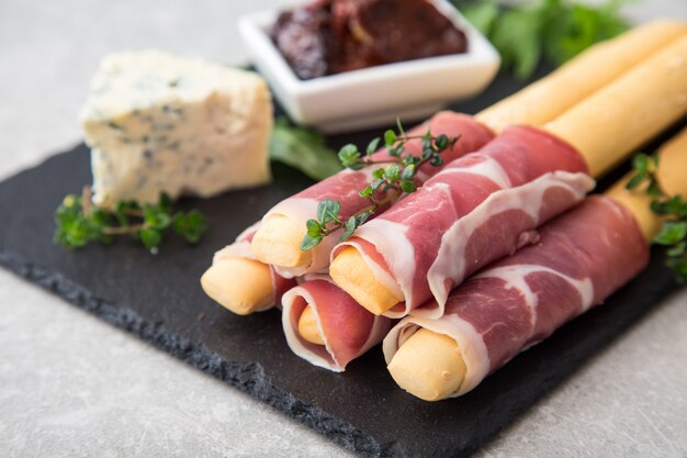 Zakąska z prosciutto, szynką, serem pleśniowym i suszonymi pomidorami na święta