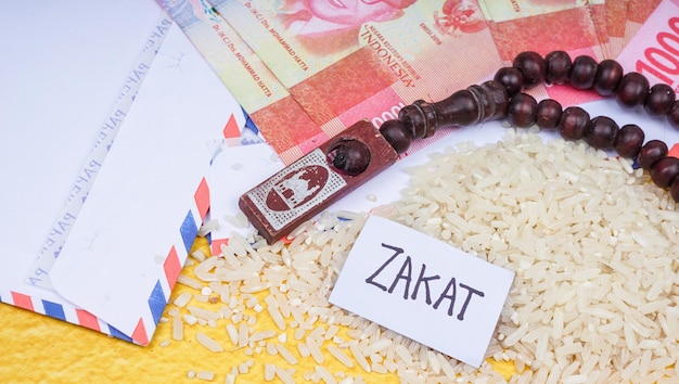Zakat islamska koncepcja ZAKAT sformułowania monety ryżowe muzułmańskie koraliki modlitewne i indonezyjska rupia pieniędzy