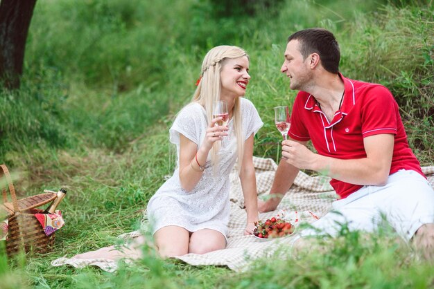 Zakochana para na pikniku w parku z zieloną trawą