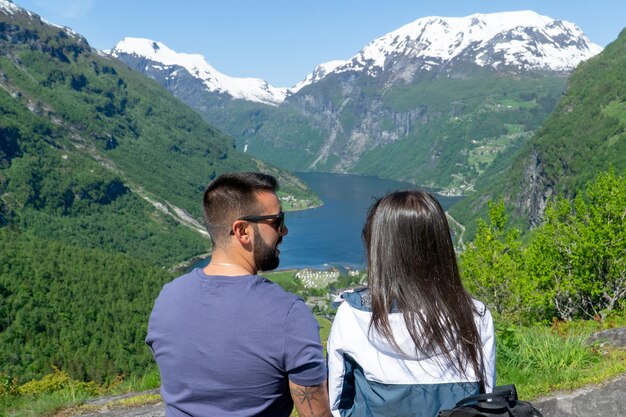 Zakochana para patrząca na siebie z Geirangerfjordem w tle w słoneczny dzień