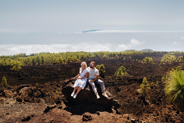 Zakochana para siedzi na zboczu wulkanu Teide Pustynny krajobraz na Teneryfie Park Narodowy Teide Teneryfa Hiszpania