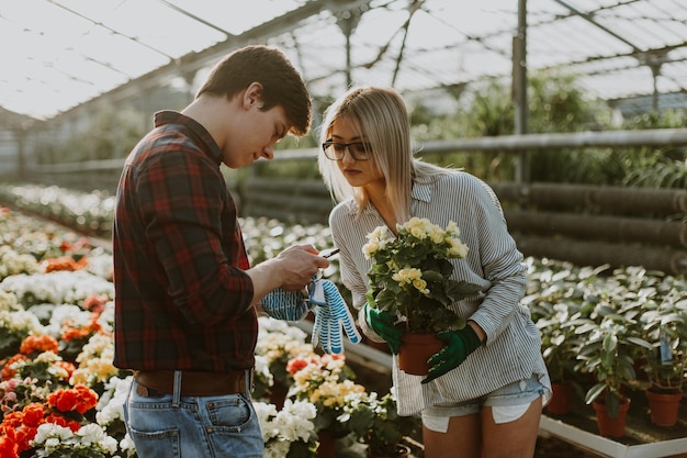 Zakochana para w szklarni robi zdjęcia kwiatów