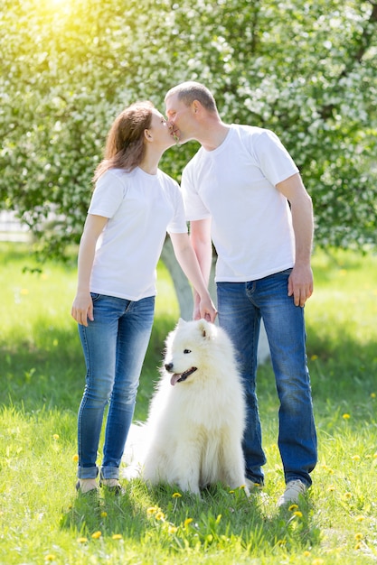 Zakochani ludzie chodzą z psem po wsi.