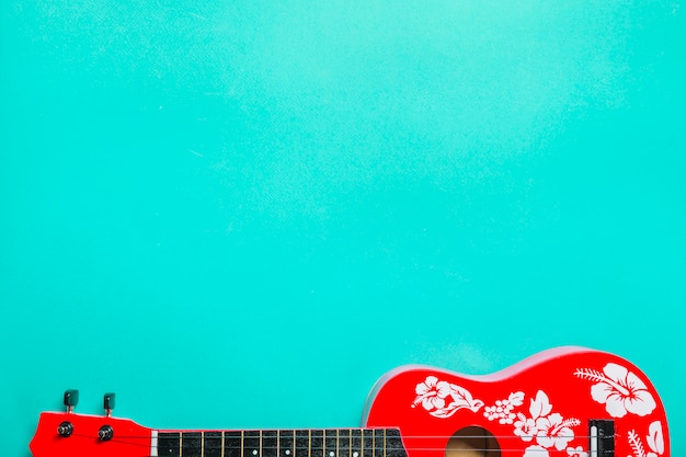 Zdjęcie zakończenie czerwona akustyczna klasyczna gitara na turkusowym tle