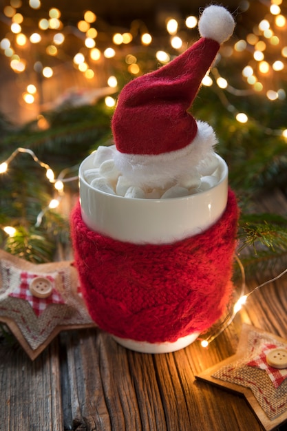Zakończenie fotografia filiżanka z gorącym napojem, marshmallow i Santa kapeluszem ,. Ozdoba z Bożym Narodzeniem
