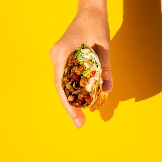 Zdjęcie zakończenie osoba trzyma smakowitego burrito