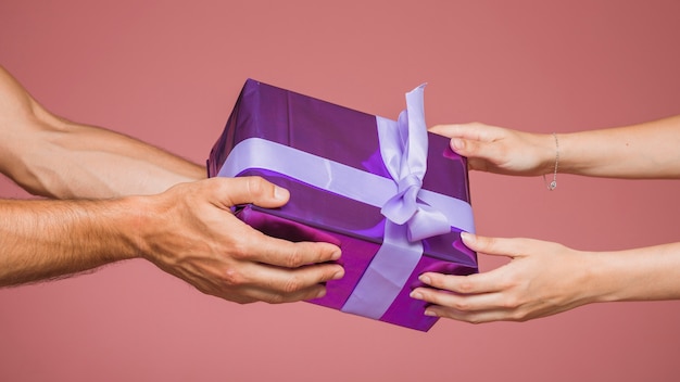 Zdjęcie zakończenie pary mienia opakunkowy purpurowy prezenta pudełko przeciw barwionemu tłu