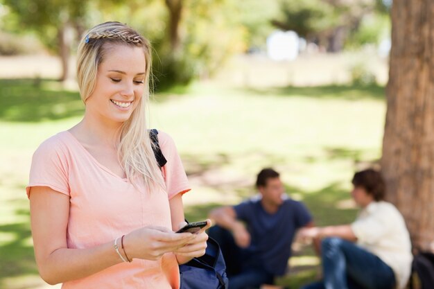 Zakończenie uśmiechnięta dziewczyna używa smartphone