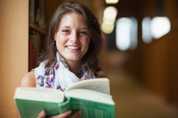 Zakończenie uśmiechnięty żeński uczeń w bibliotece