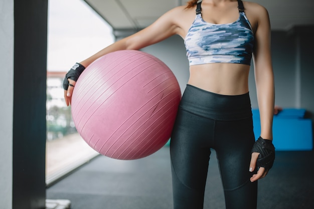 Zakończenie w górę azjatykciego kobieta modela trzyma joga piłkę przy gym narządzaniem dla ćwiczenia, ćwiczenie dziewczyna