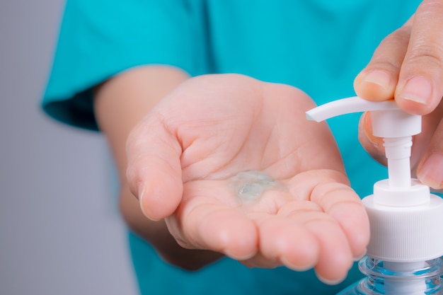 Zakończenie w górę kobiety ręki bierze cleaner od alkoholu sanitizer butelki.