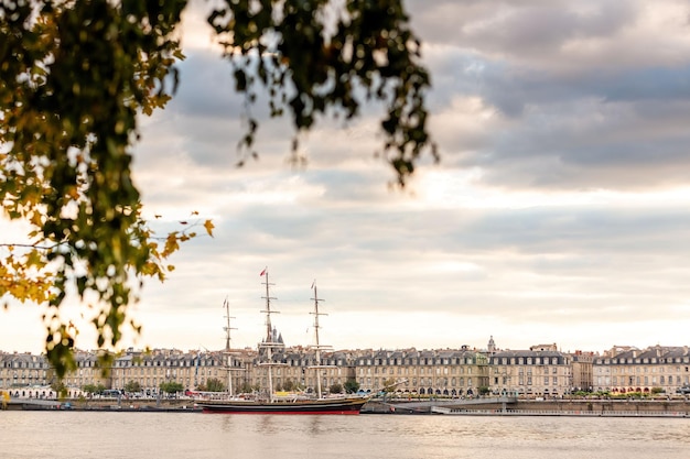 Zakotwiczony żaglowiec z budynkami miejskimi w tle. Bordeaux, Francja.