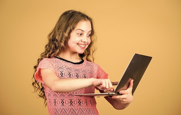 Zakupy online projekt szkolny szczęśliwa mała dziewczynka z notebookiem rozwój dziecka w erze cyfrowej rozmowa wideo przez kamerę internetową edukacja domowa edukacja biznes wideokonferencje Nudna praca domowa