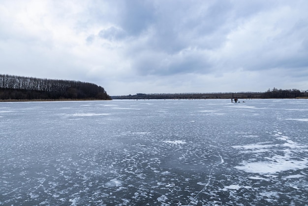 Zamarznięta rzeka pokryta lodem w mroźnym zimowym krajobrazie
