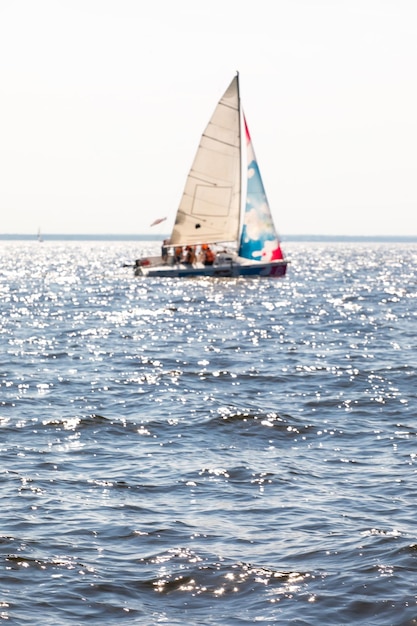 Zdjęcie zamazany jacht z podniesionymi żaglami nieostry żaglowiec na pełnej prędkości na horyzoncie morza