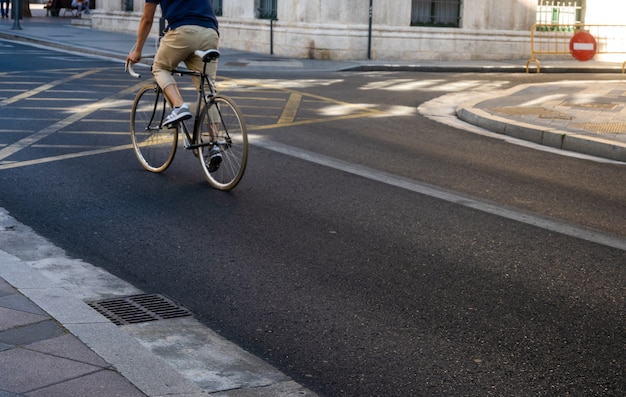 Zamazany obraz mężczyzny jadącego na rowerze w miejskim mieście dojeżdżającym z prędkością i modnym transportem hipster