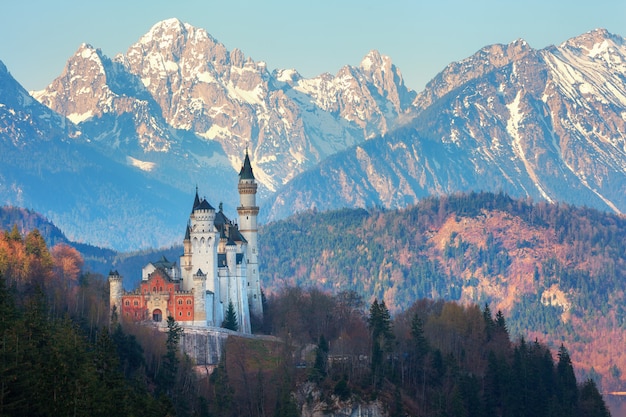 Zamek Neuschwanstein w tle zaśnieżonych gór