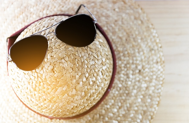 Zdjęcie zamknięte okulary przeciwsłoneczne i słomkowy kapelusz