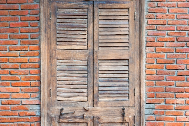 Zamknięty drewniany drzwi z czerwonych cegieł ścianą w starym rocznika domu.