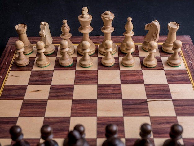 Zamknij domyślną pozycję w szachowej grze planszowej na czarnym stole