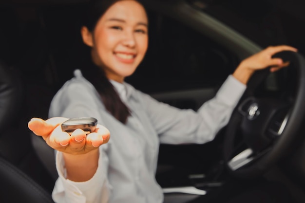 Zamknij się azjatycki bizneswoman, trzymając nowe kluczyki do samochodu z salonu nowoczesnego serwisu auto.