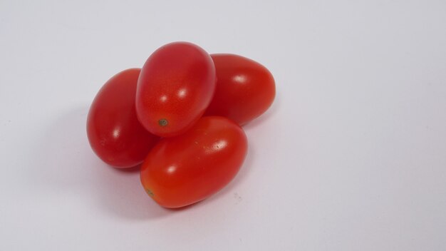 Zamknij się grupa pomidorów cherry na białym tle.