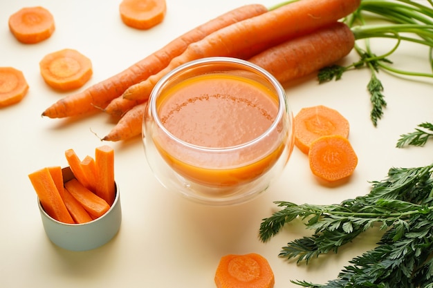 Zamknij się na składzie z dojrzałymi świeżymi marchewkami, sokiem i plasterkami
