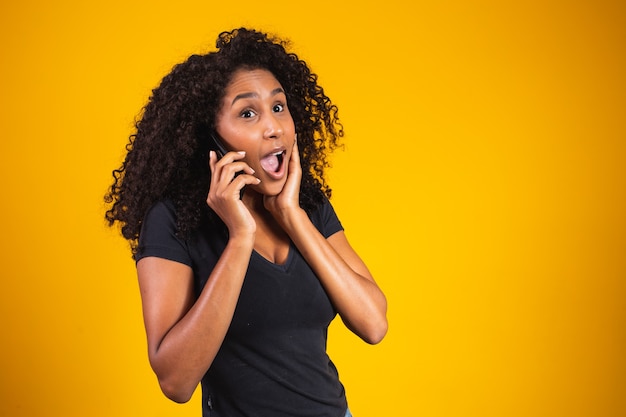 Zamknij Się Portret Szczęśliwej Afroamerykańskiej Młodej Kobiety Rozmawiającej Z Telefonem Komórkowym W żółtym Tle