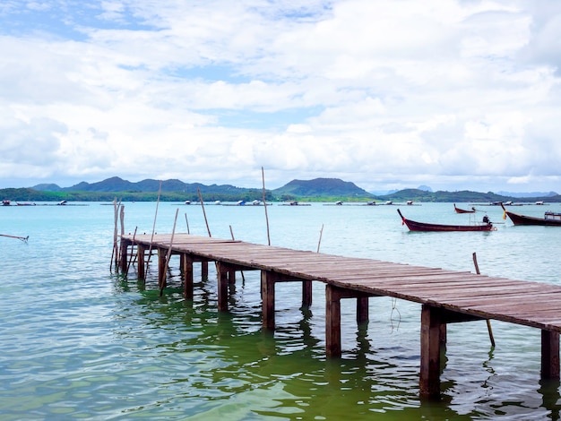 Zamknij się puste drewniane molo z łodzi lokalnych rybaków na tle morza i nieba w Tajlandii.