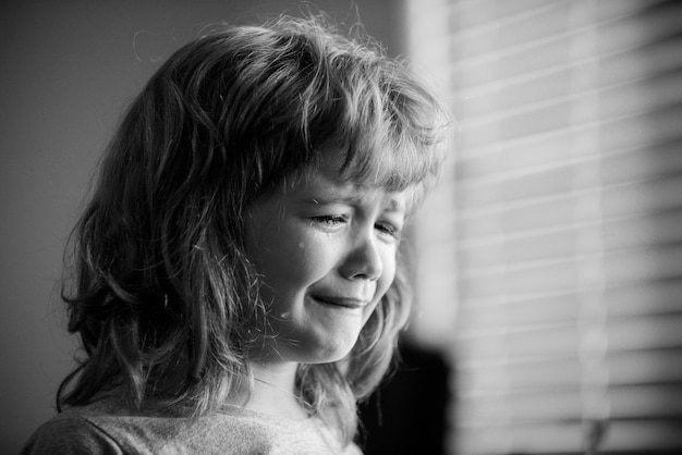 Zamknij się twarz płaczącego chłopca smutne dziecko ze łzami w domu