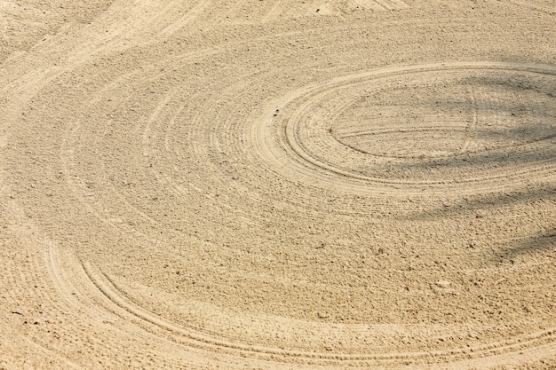 Zdjęcie zamknij się w tle tekstury surowego pola piasku z wielu linii okręgu na polu golfowym