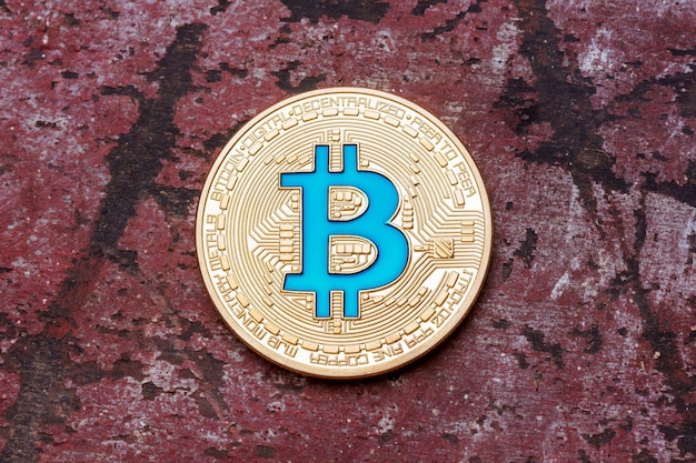 Zamknij się złoty kryptowaluta niebieski bitcoin na czerwonym tle. Zdjęcie w wysokiej rozdzielczości.