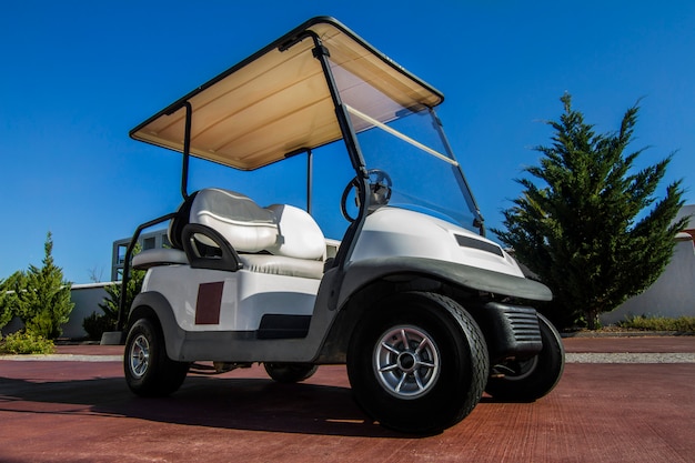Zamknij widok białego wózka golfowego zaparkowanego na drodze.