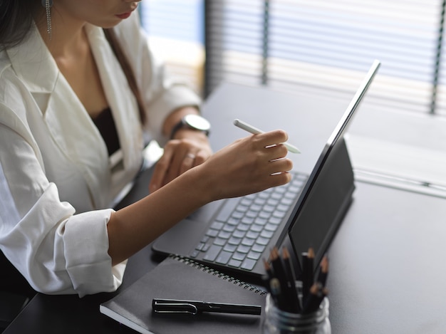 Zamknij widok młodej bizneswoman pracy z tabletem w biurze