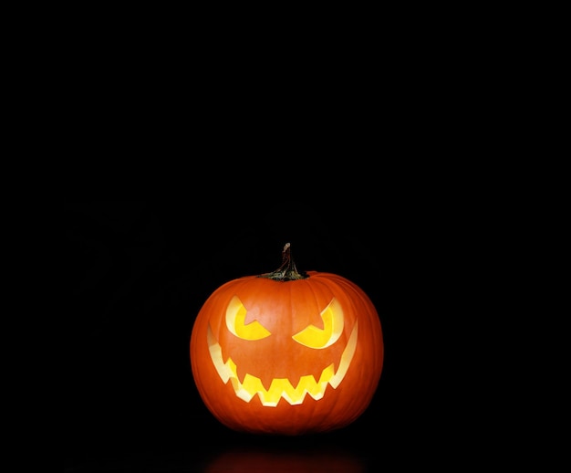 Zdjęcie zamknij widok przerażającej dyni halloween z oczami świecącymi w środku