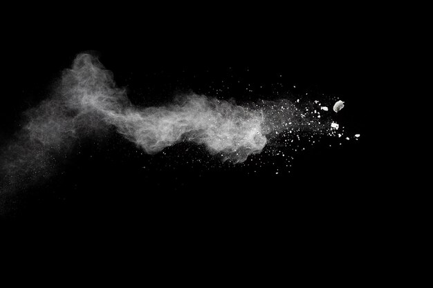 Zamrożenie ruchu białych cząstek pyłu na czarnym tle białe chmury wybuchu proszku