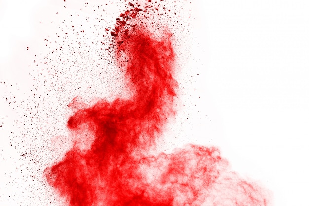 Zdjęcie zamrozić ruch czerwony proszek wybuchu, na białym tle.