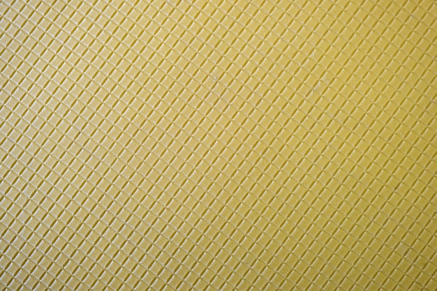 Zamyka up abstrakcjonistyczny żółty tło z geometrycznym wzorem.