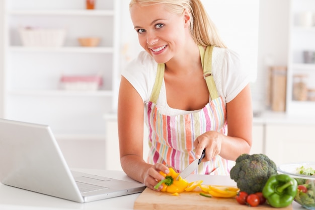 Zamyka up blondynki kobieta używa laptop gotować