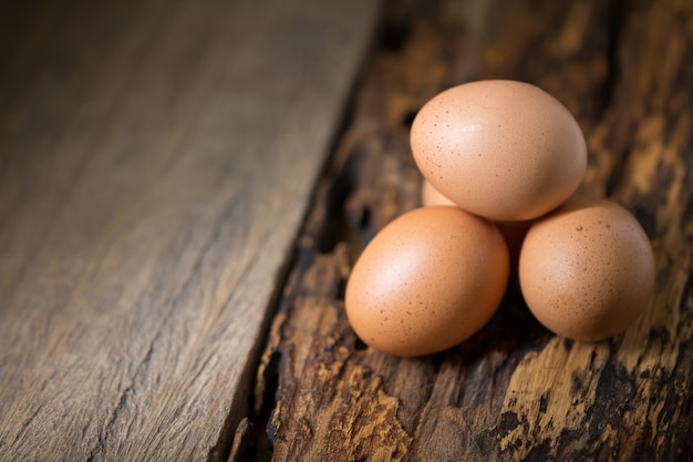 Zamyka up jajka na drewnianym stołowym tle