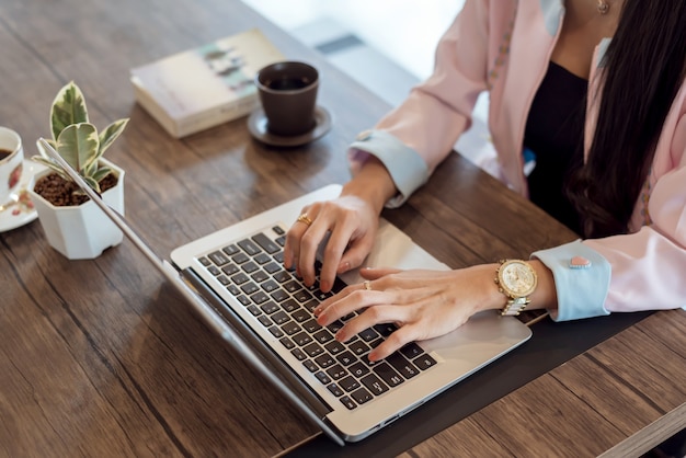 Zamyka up Młody bizneswoman pracuje na laptopie