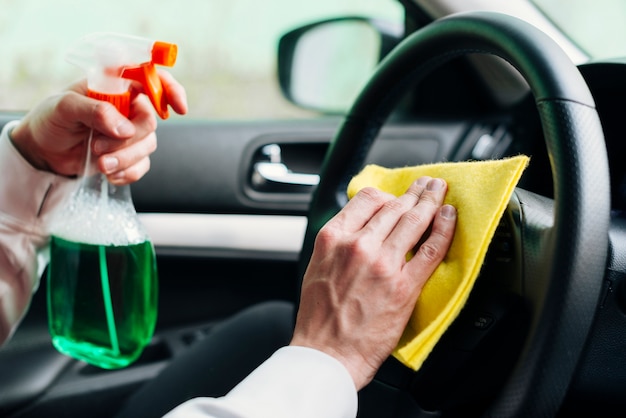 Zdjęcie zamyka up osoby cleaning samochodu wnętrze