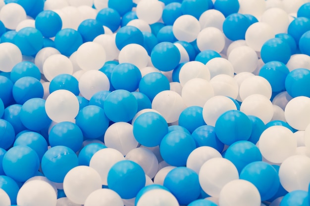 Zamyka up plastikowe białe i błękitne piłki w suchym basenie na boisku