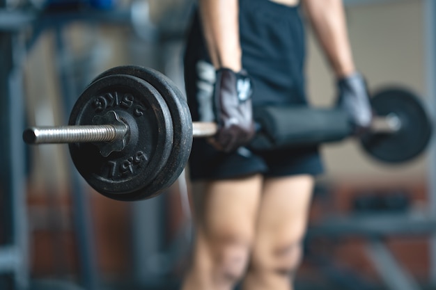 Zamyka w górę ćwiczenie barbell w gym