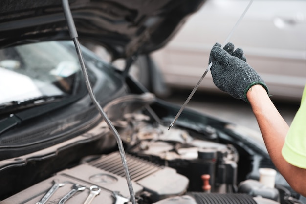 Zamyka W Górę Mechanik Ręk Sprawdzać Up Sprawność Fizyczna Samochód W Otwartym Kapiszonie, Parowozowy Olej