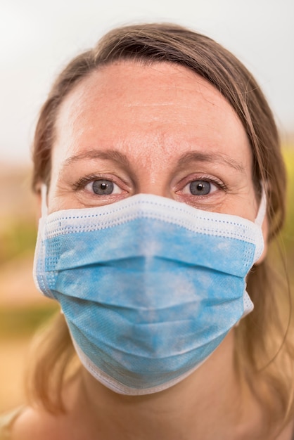 Zdjęcie zamyka w górę portreta kobieta patrzeje kamerę z maską ochronną.