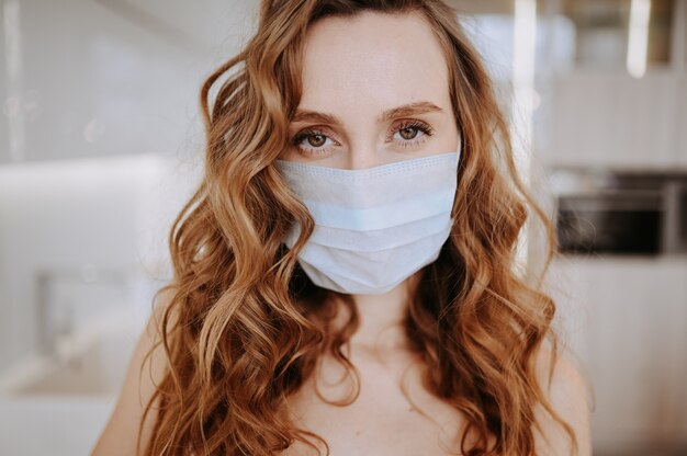 Zamyka w górę portreta piękna młoda europejska kobieta jest ubranym maskę ochronną dla zapobiegania wirusa korony słonecznej, higiena zatrzymywać rozprzestrzeniania koronawirusa. Unikaj zanieczyszczenia koncepcji wirusa Covid-19 wirusa korony
